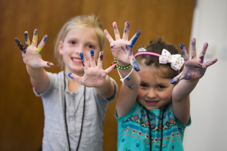 Kids with paint on their hands.