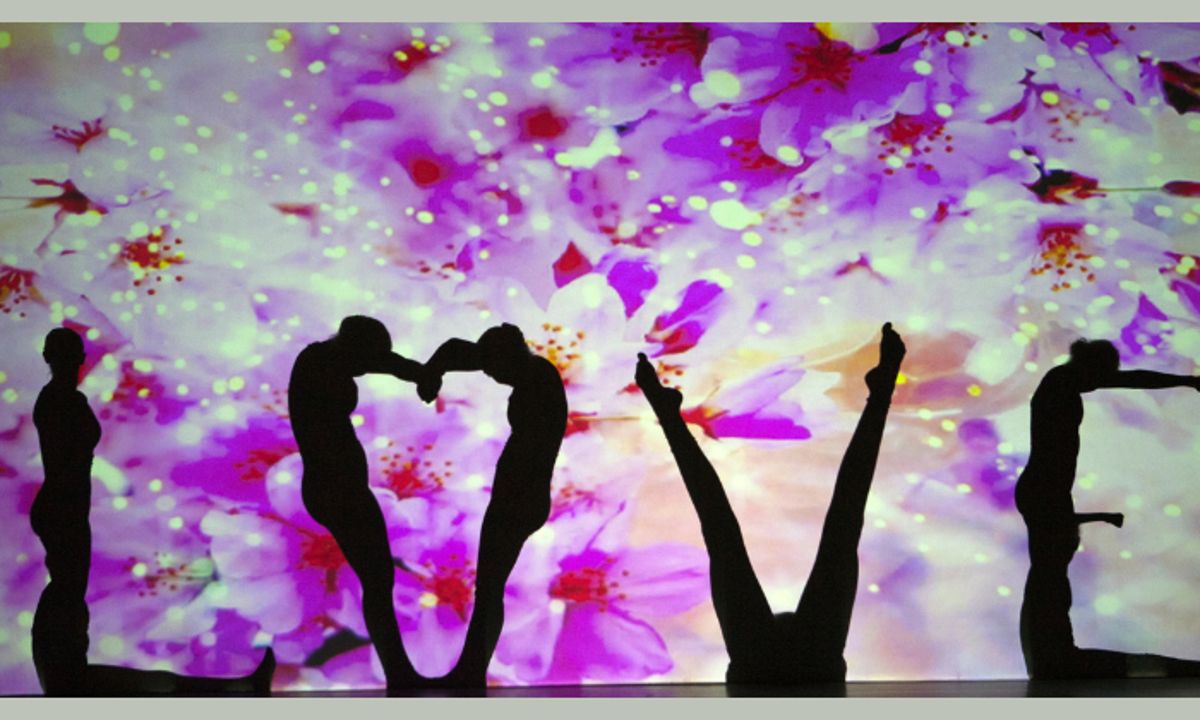 People posing so that their silhouettes spell "love".
