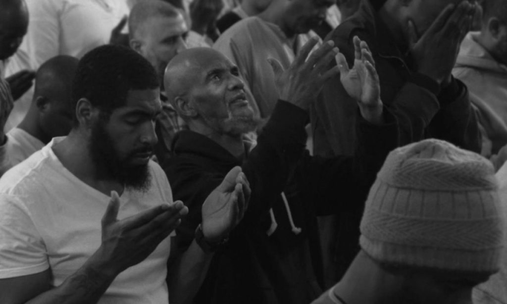 Crowd of men praying.