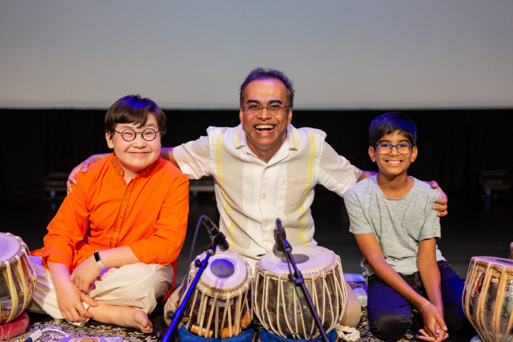 Sandeep Das invites children onstage during a performance at the Ware Center