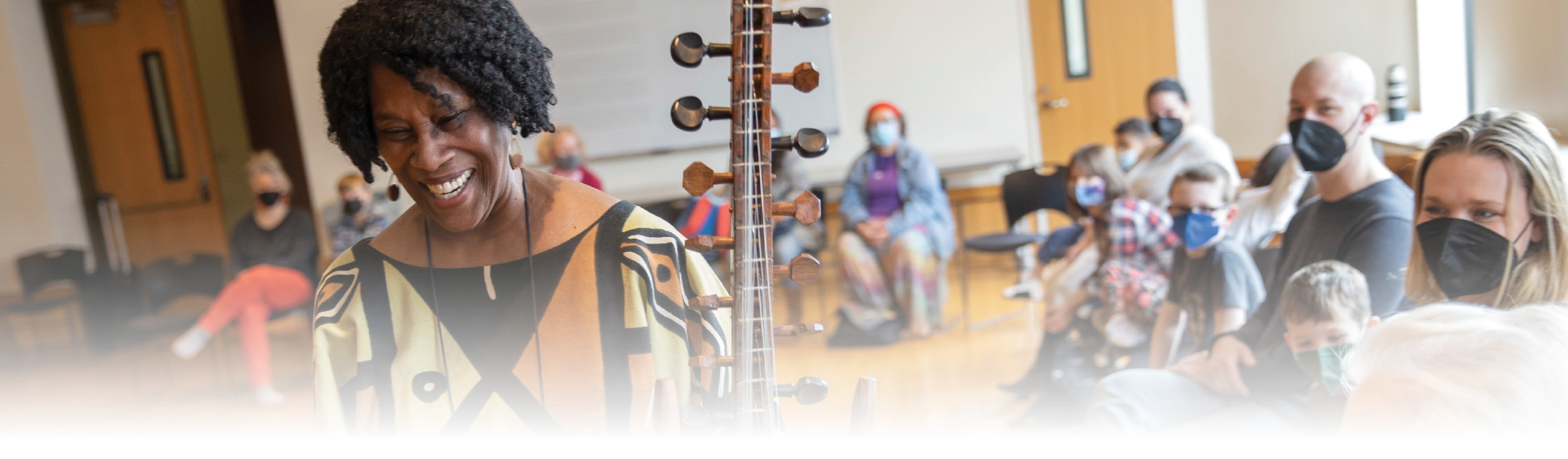 A woman demonstrates an instrument to a class in the Ware Center