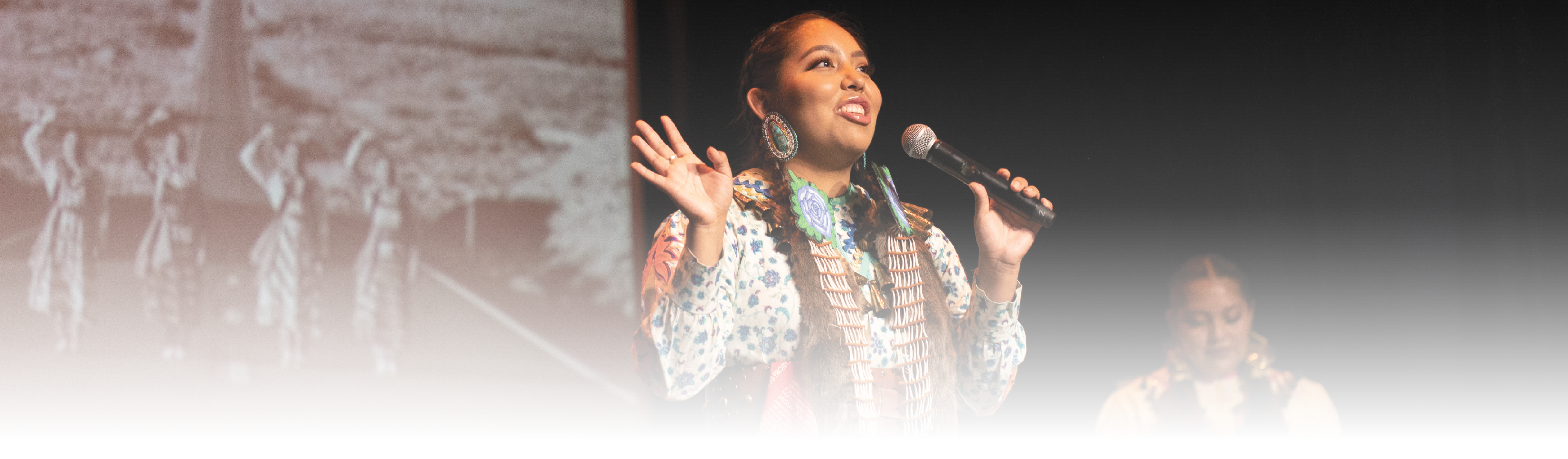 An indigenous woman performs onstage
