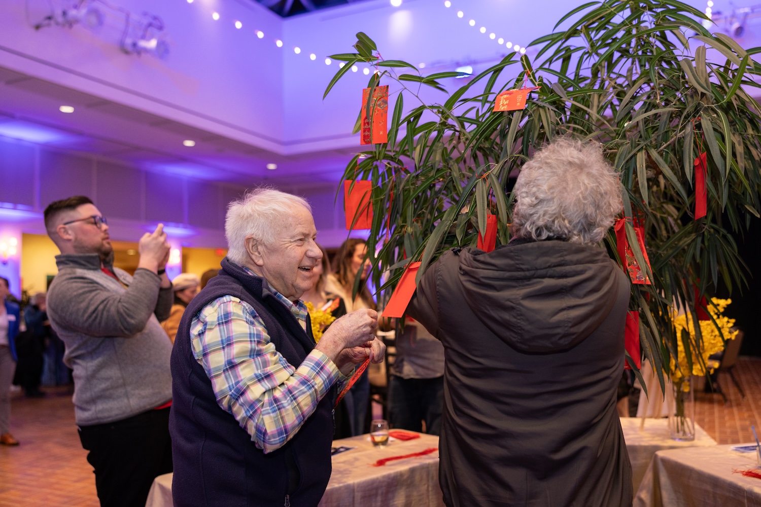 Visitors hang New Year's wishes on a tree at the Our Journeys opening event