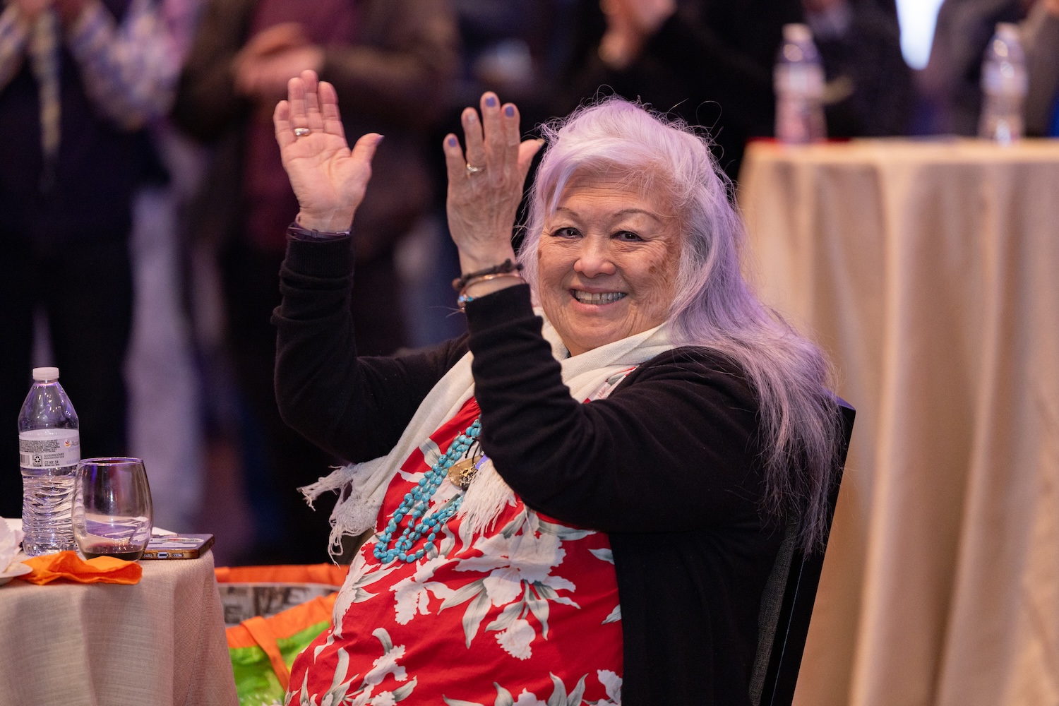 A visitor applauds at the Our Journeys opening event