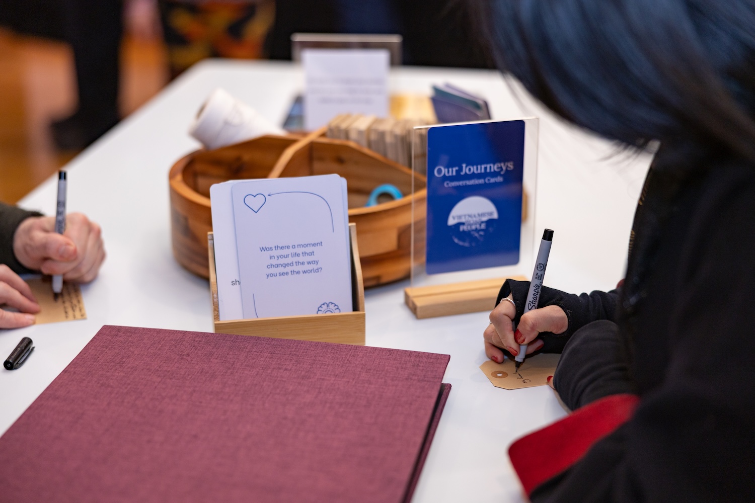 Visitors write their families' stories on cards to add to the Our Journeys map